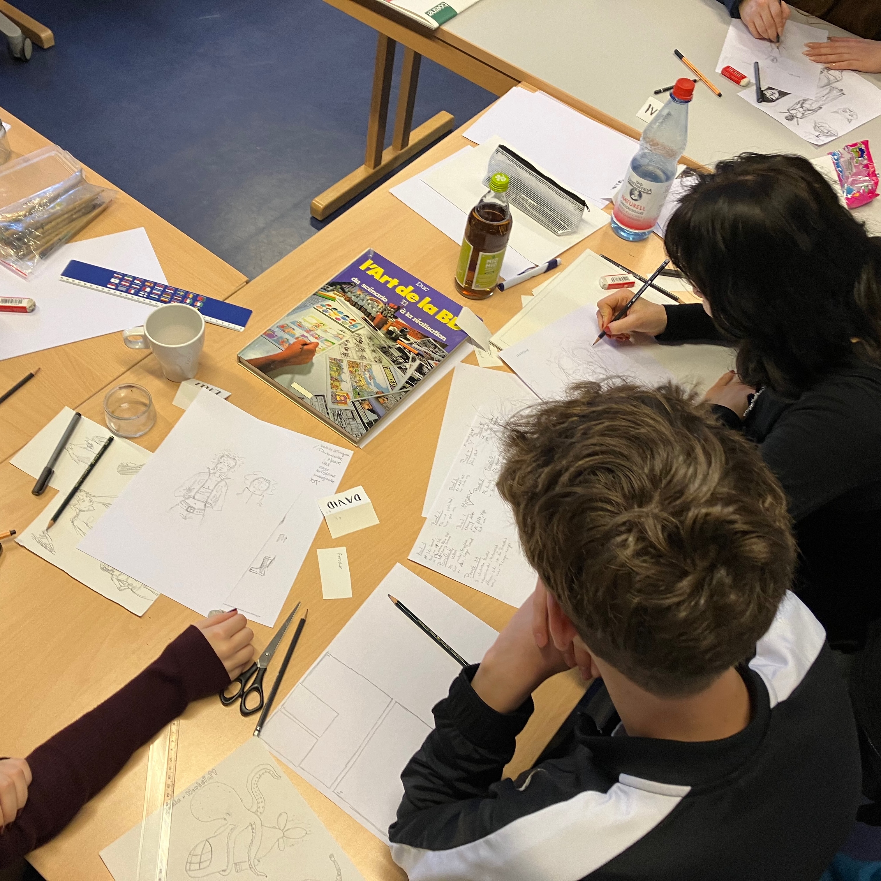 Junge Menschen beim Zeichnen von Comicseiten